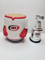 Mini Stanley Cup trophy and jersey-style beer koozie side by side