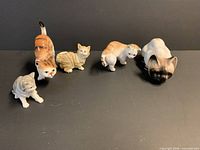 Group view of five porcelain cat figurines