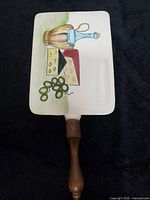 Front view of ceramic cheese board showing artwork and handle