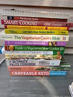 Stack of 12 cookbooks showing spines and titles