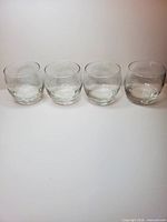 Four Courvoisier branded glasses aligned side by side