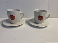 pair of white Grand Marnier cups on saucers