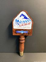 Front view of wooden Kokanee Light tap handle showing logo, shape and brass ferrule
