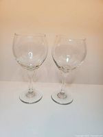 Pair of large clear wine glasses standing side by side