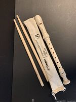 Recorder, bag, and two drumsticks laid out