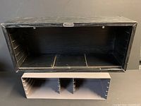 Front view of both storage units; shows black wood Nintendo shelf above grey plastic rack