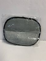 Grey pet hair removal glove in sealed plastic package