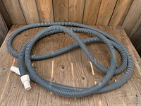 Coiled corrugated pool hose showing full length and striping