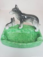 Front view showing green ashtray base, standing dog, seated puppy
