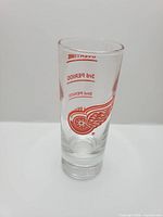 Front view of tall shot glass showing team logo and measurement markings