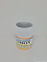 Front view of ceramic shot glass showing prescription bottle styling and printed label