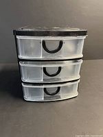 Front view showing clear drawers, black frame and handles