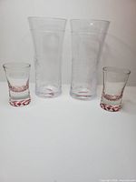 Two highball glasses and two shot glasses grouped