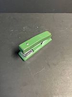Side view of green metal stapler closed