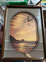 Front view showing ocean scene, mirrored border, numerals and hands