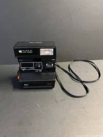 Front view showing Polaroid 600 Land Camera Sun 650 with strap attached