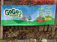 Front view of GoGo Squeez vinyl banner showing full graphics and grommets