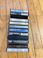 Stack of 11 cassette tapes showing visible spine titles