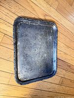 Top view of rectangular silver-plated tray showing ornate rim and surface wear