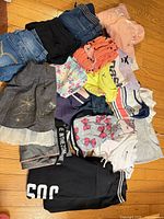 Entire lot piled on floor showing variety of clothing pieces