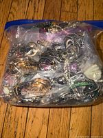 Front view of sealed bag showing large quantity of assorted jewelry pieces