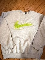 Full view of gray sweatshirt with lime green fur swoosh