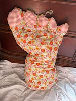 Front view of the oversized floral foot-shaped pillow showing floral body and gingham toes