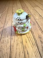 Front view of ceramic honey pot showing floral and bee design