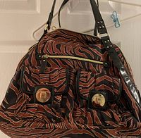 Front view showing brown/black animal print, two flap pockets with Franco Sarto logo plates, zipper pocket, handles and trim