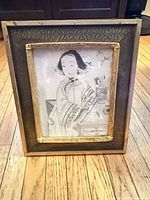 Full view of framed artwork standing on floor