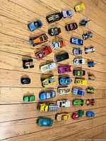 Top-down view of all 39 vehicles displayed on wooden floor