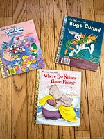 All three Little Golden Books displayed cover up on wood floor