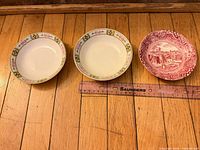 Top view of three patterned dipping bowls beside ruler