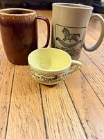 Overall view of all three mugs standing on wooden floor