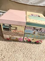 Front view of all four stacked boxes showing designs and lids