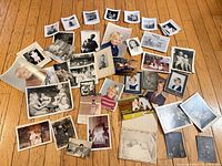 Overall spread of approximately 40 vintage photographs on wooden floor