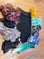 All ten scarves arranged around black embroidered shawl