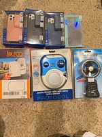 All items laid out: four phone cases, Burco mirror glass, Protocol shower radio, Wind Blaster fan