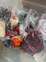 Plastic tub containing multiple sealed bags of ribbon and novelty yarn