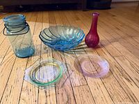 Group shot of all five colored glass pieces on wood floor