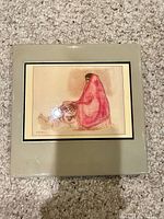 front of square ceramic tile showing Navajo woman artwork