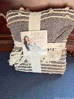 Front of folded throw with retail band and tag visible