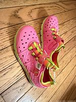 Top view showing both sneakers, perforated pink upper and lime green trim