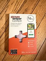 Front of retail box showing Picture Keeper Connect 16GB drive and compatible devices