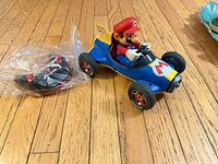 Full view of Mario Kart RC car with remote beside it