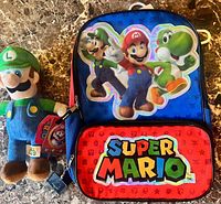 Backpack and Luigi plush displayed together on tabletop