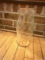 Full view of glass hurricane shade showing angel design and gold rim