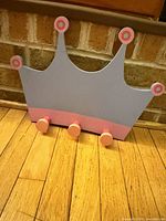 Front view showing crown shape, colors, three peg hooks