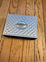 Top view showing silver-tone quilted lid with oval cartouche