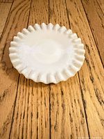 Top view showing ruffled edge milk glass plate